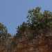 ...circondata da alte spalle rocciose rossastre su cui fanno capolino alberi da frutto e fichi dindia